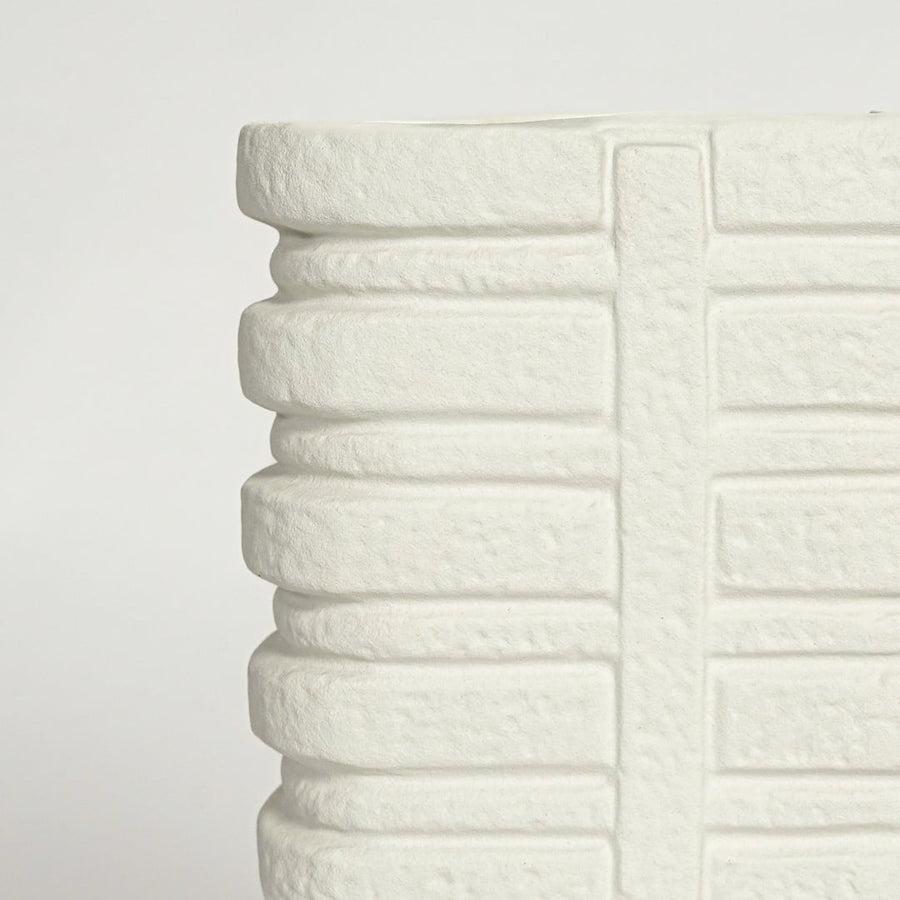 Close up view white ceramic vase showing layered ribbed texture sculpted vertical pattern modern decor accent.