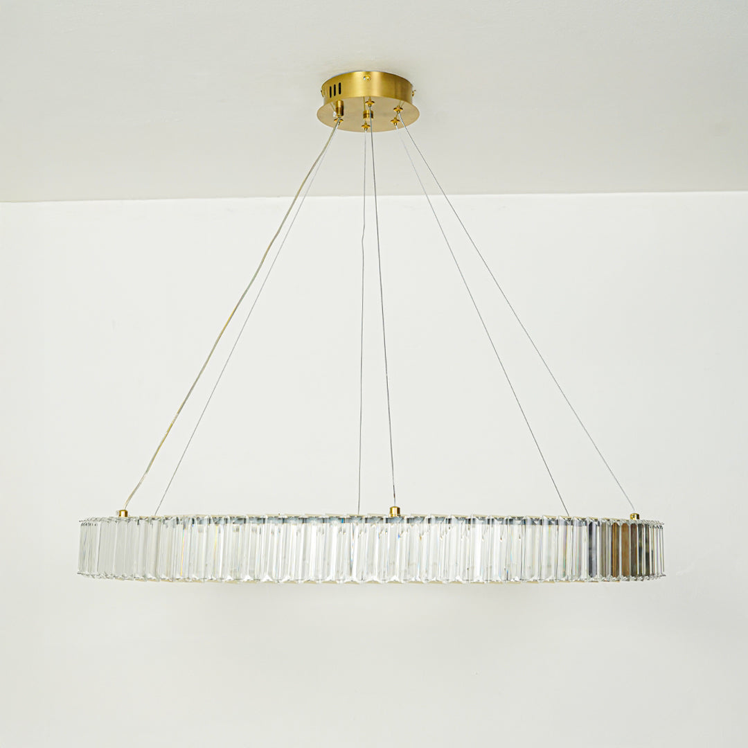 Stylish rectangular crystal pendant light with gold ceiling base hanging against minimal white background perfect for luxury interior lighting setup.