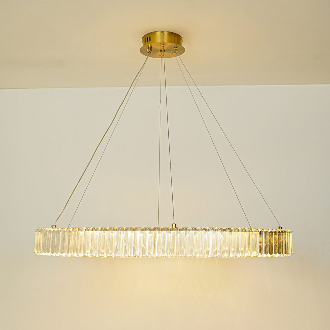 Modern crystal chandelier with gold ceiling mount installed in luxury hallway with wooden console and arched window background for elegant interior lighting.