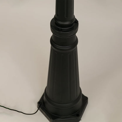 Closeup of black metal dual lantern lamp post showing ribbed glass and ornate curved arms perfect for enhancing garden driveway and home entrance Decor.