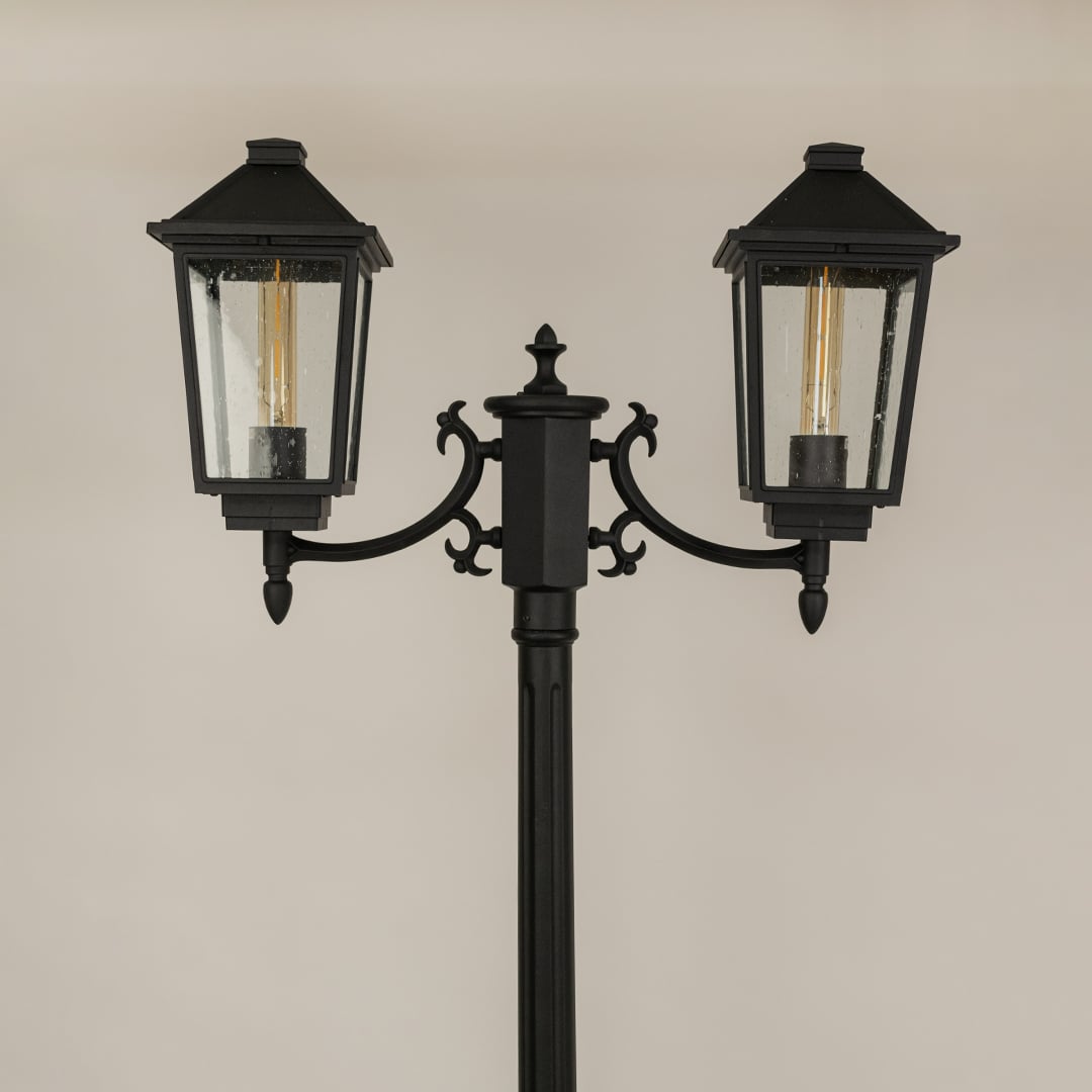 Detailed closeup of black metal lantern head with ribbed glass and classic silhouette ideal for outdoor walkway patio garden and exterior Decor.