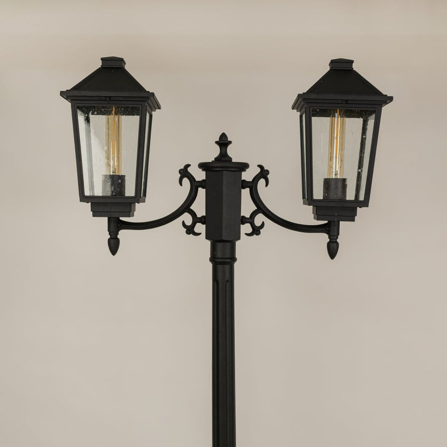 Detailed closeup of black metal lantern head with ribbed glass and classic silhouette ideal for outdoor walkway patio garden and exterior Decor.