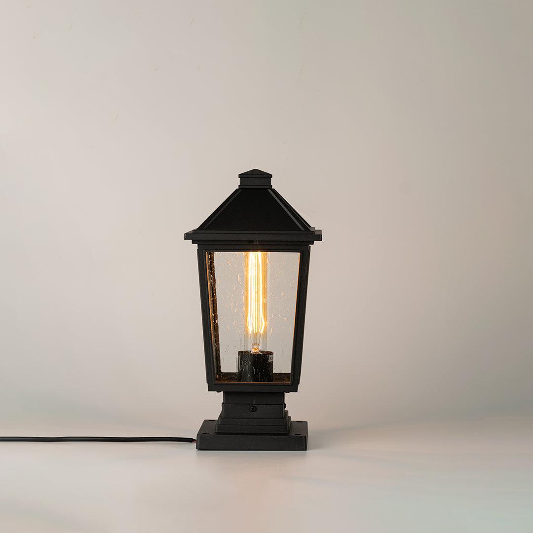 Black outdoor gate light with ribbed glass panels for stylish modern exterior decor use.