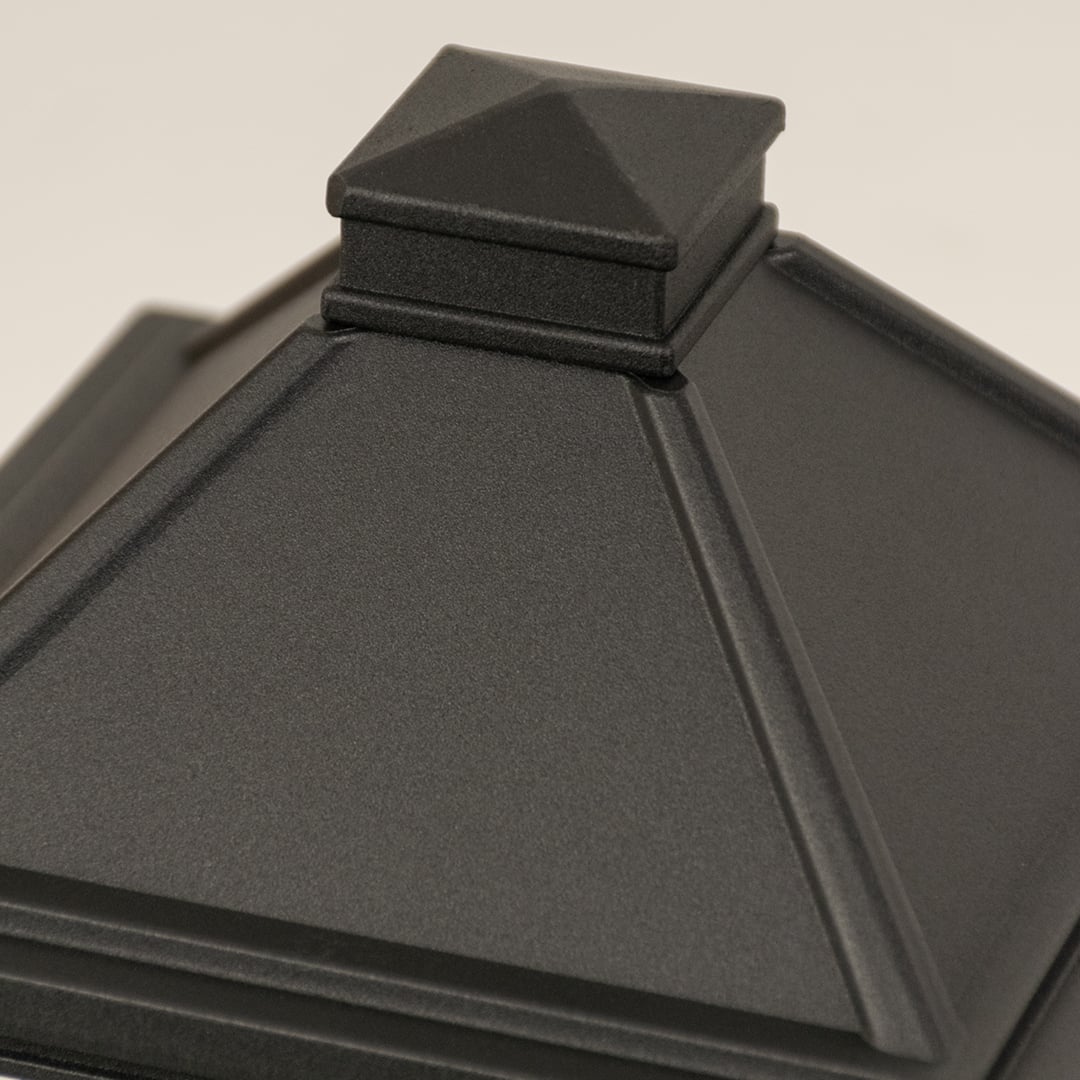 A side angle closeup of the black outdoor post light showcasing the smooth metal finish and patterned glass surface with strong detailing.