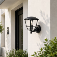 Modern black metal outdoor wall light for porch entrance patio and exterior walls with elegant warm ambient lighting.