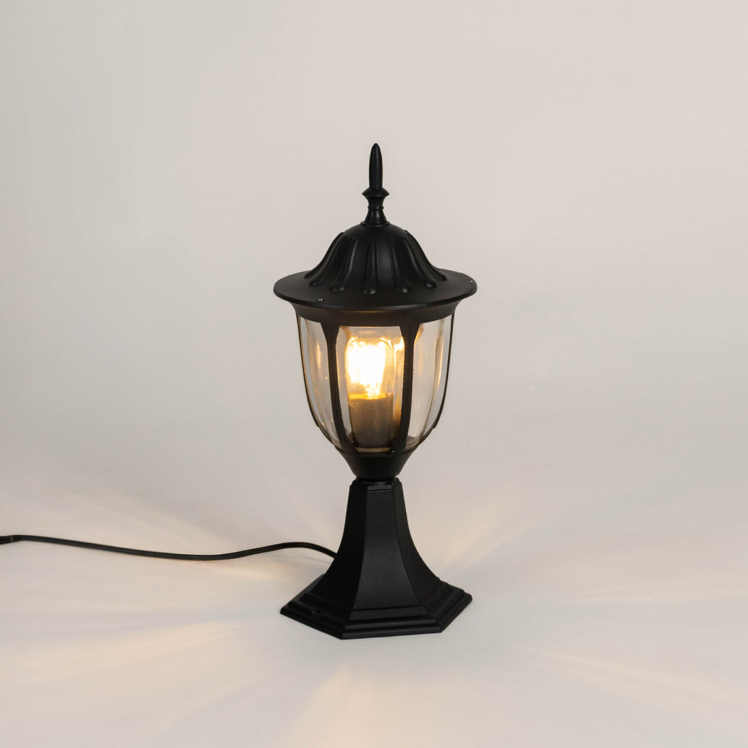 Vintage black outdoor gate light with warm glowing bulb for elegant exterior decor styling use.