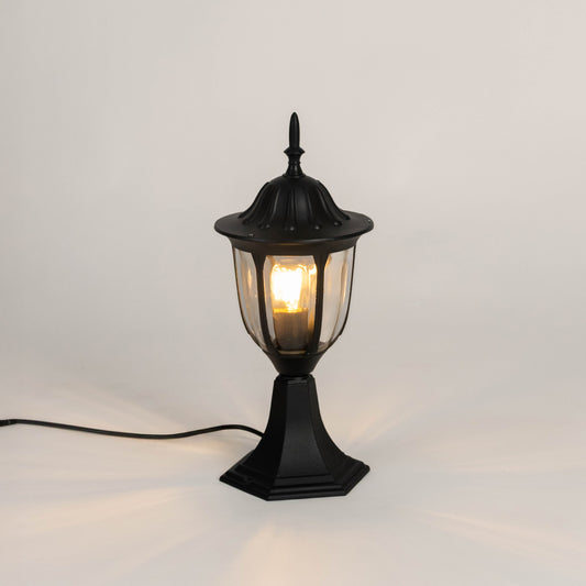 Vintage black outdoor gate light with warm glowing bulb for elegant exterior decor styling use.
