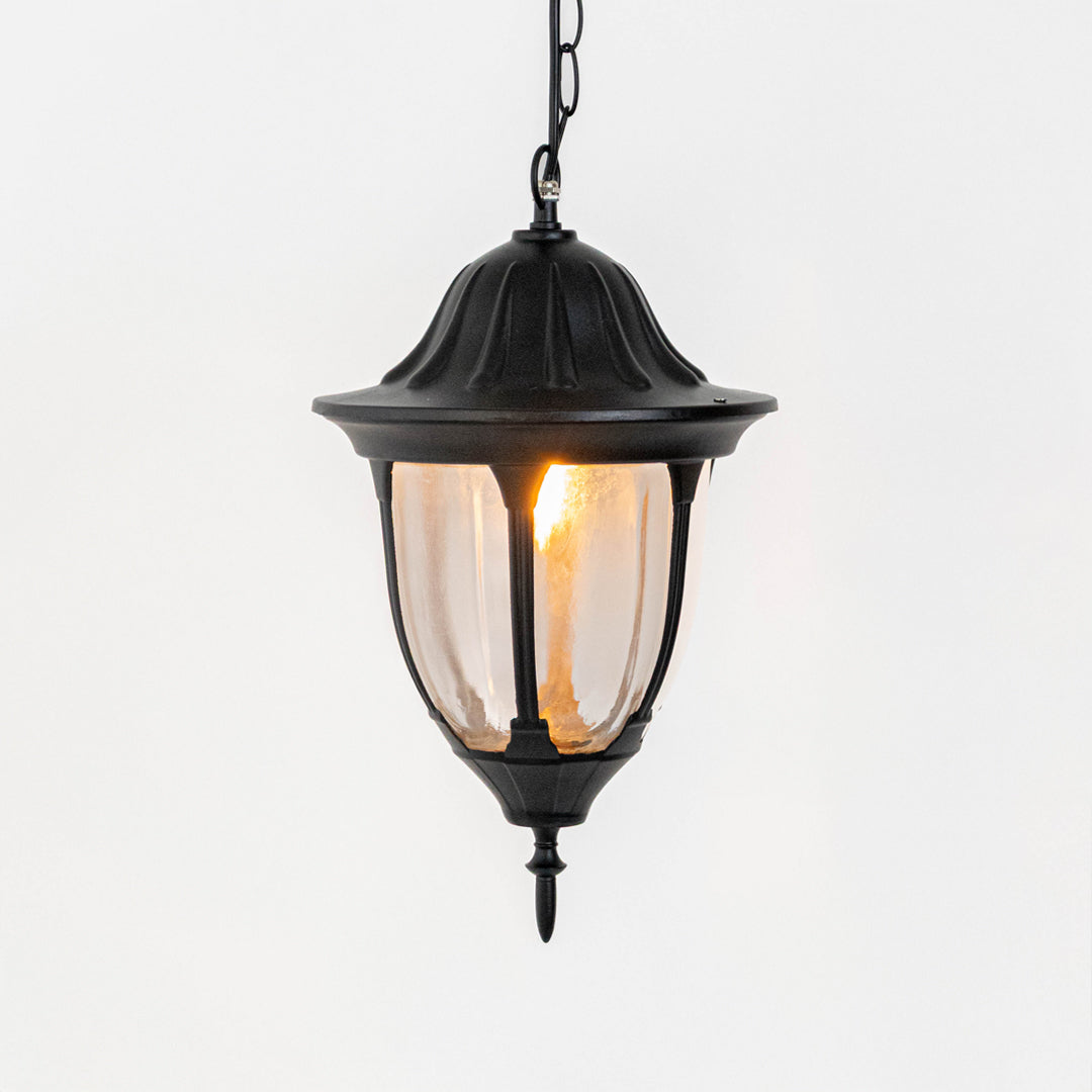 Elegant black metal hanging lantern light with warm glow for modern balcony and patio decor.