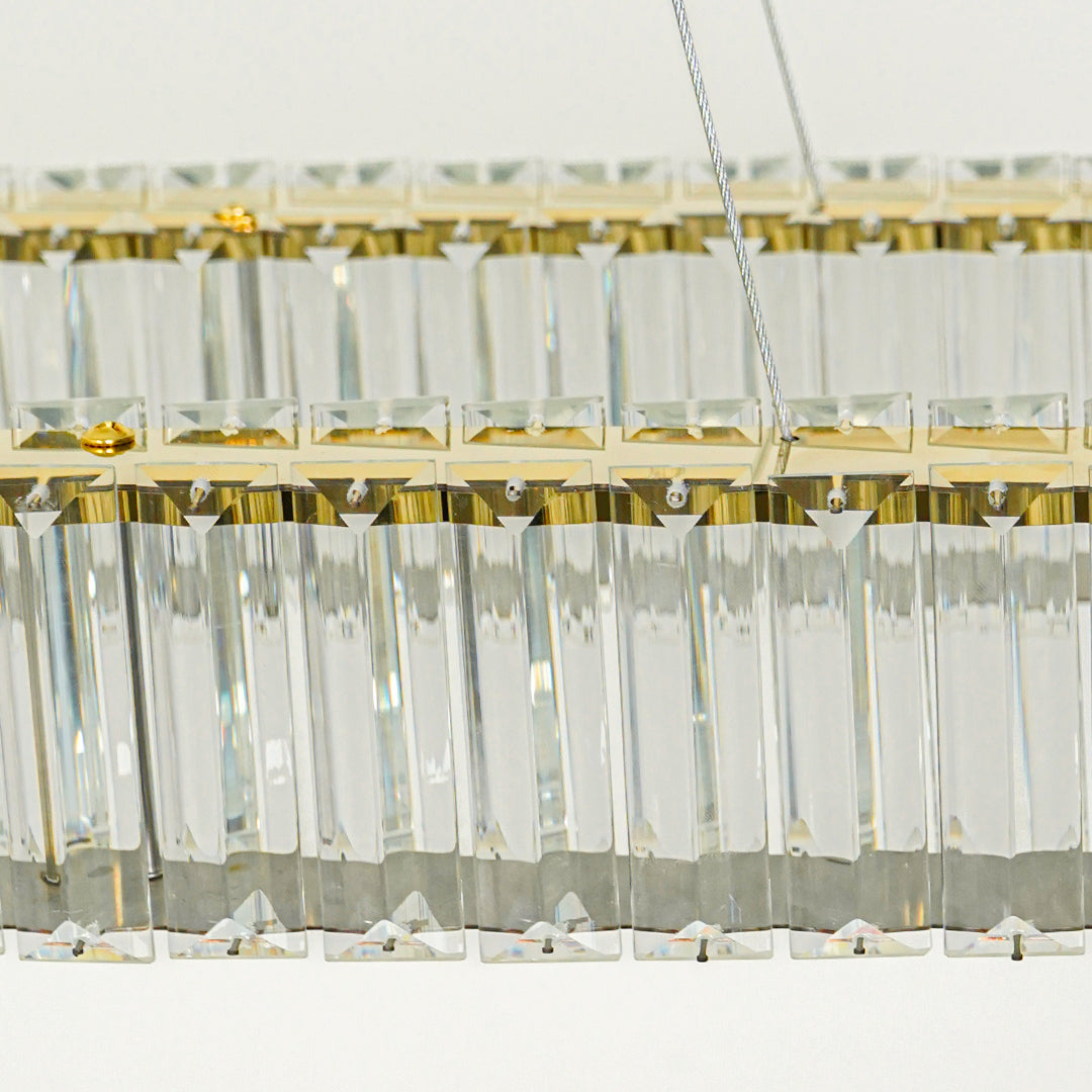 Close up crystal bar pendant light with gold metal detailing and hanging glass elements against white background perfect for elegant interior decor.