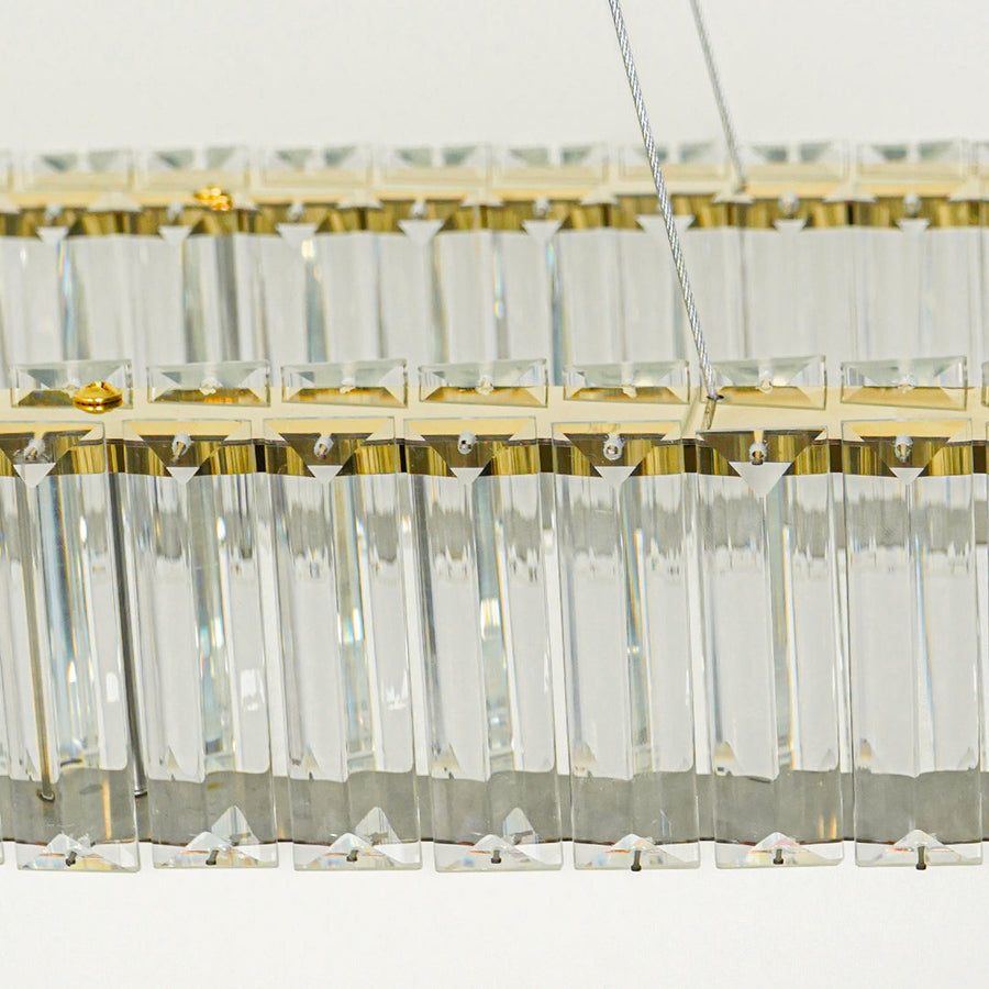 Close up crystal bar pendant light with gold metal detailing and hanging glass elements against white background perfect for elegant interior decor.