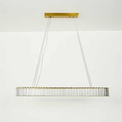 Modern crystal linear chandelier with gold metal frame suspended by cables against clean white ceiling background ideal for luxury dining lighting.