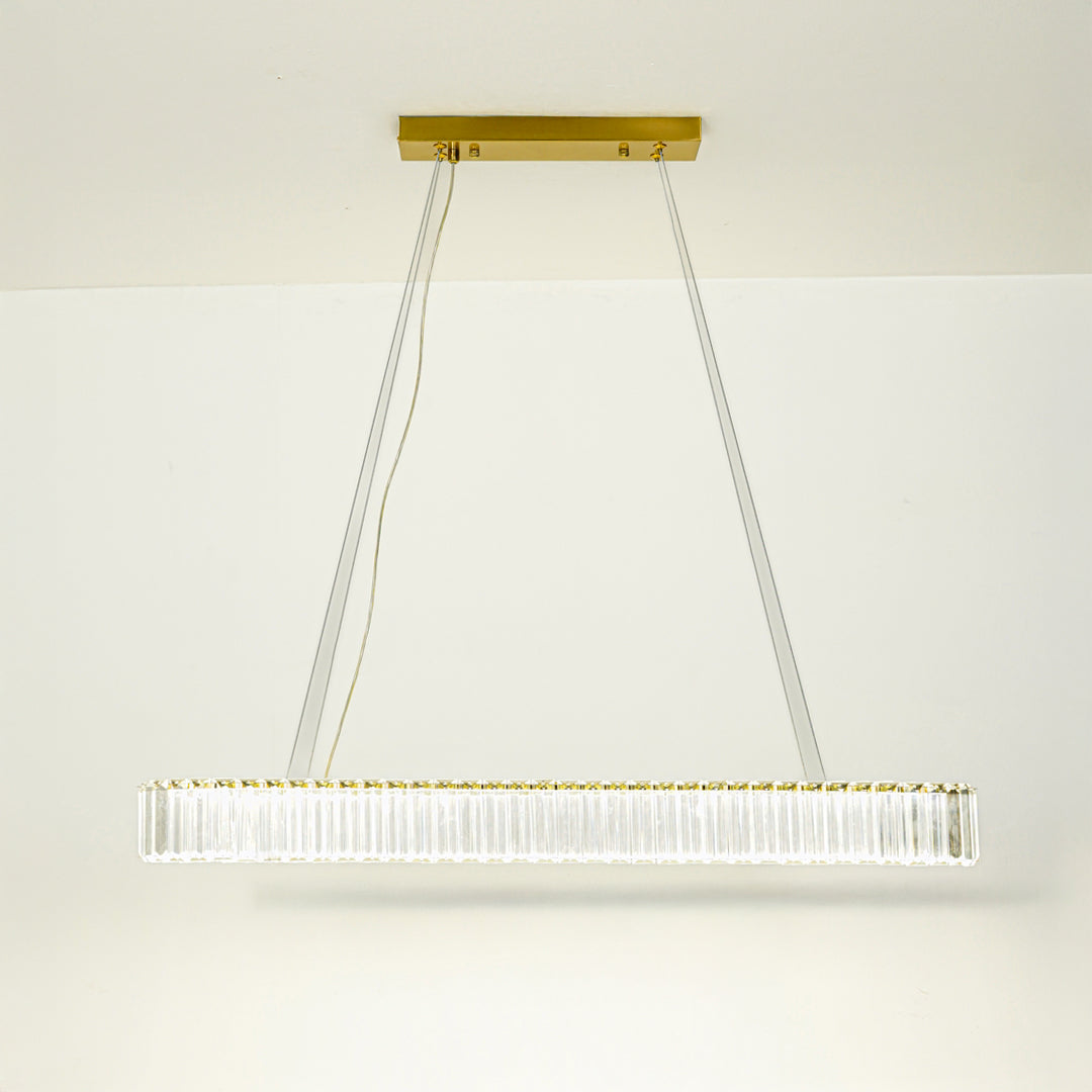 Elegant long bar pendant light with gold metal finish suspended on cables against neutral wall background ideal for luxury interior decor lighting.

