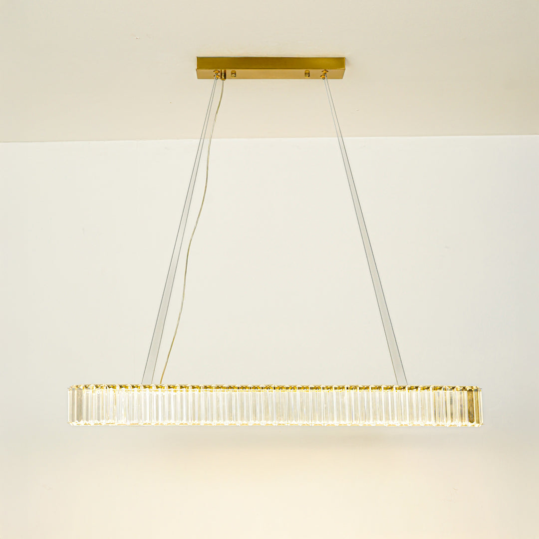 Minimal gold linear chandelier with slim design hanging against clean white ceiling background perfect for modern dining or kitchen lighting.