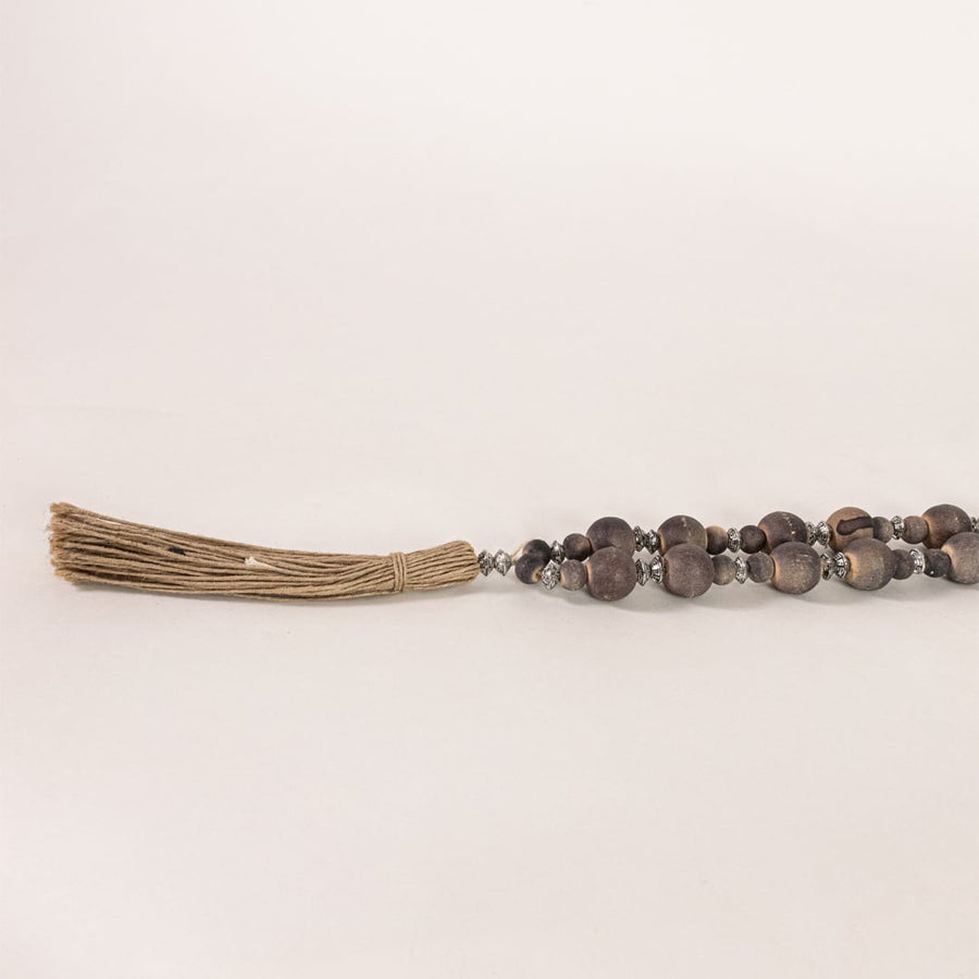 Detailed closeup of round wooden beads strung together highlighting natural tones craftsmanship and boho Decor style.