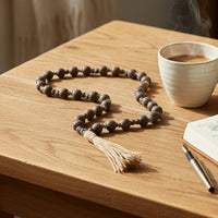 Decorative wooden bead garland with tassel styled on console or coffee table adding earthy texture to modern home Decor.
