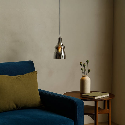 Stylish pendant light displayed in a modern lifestyle setup featuring a reflective chrome body with a smooth curved silhouette.
