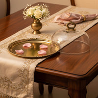 Luxury gold metal serving tray lifestyle image with glass cover and floral accents for elegant dining decor.