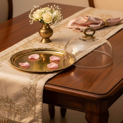 Luxury gold metal serving tray lifestyle image with glass cover and floral accents for elegant dining decor.