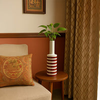 A tall striped decorative vase displayed in a soft lifestyle setting adding a modern artistic touch to home decor with its bold pattern and sleek shape.