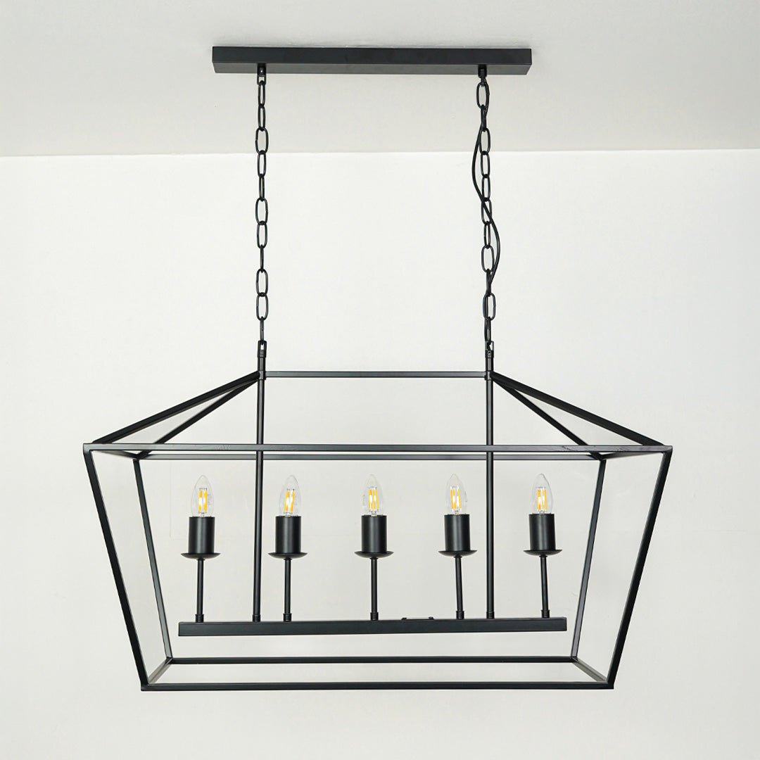 Black metal rectangular chandelier with candle style lights suspended by chain against neutral background ideal for dining table lighting in modern interiors.