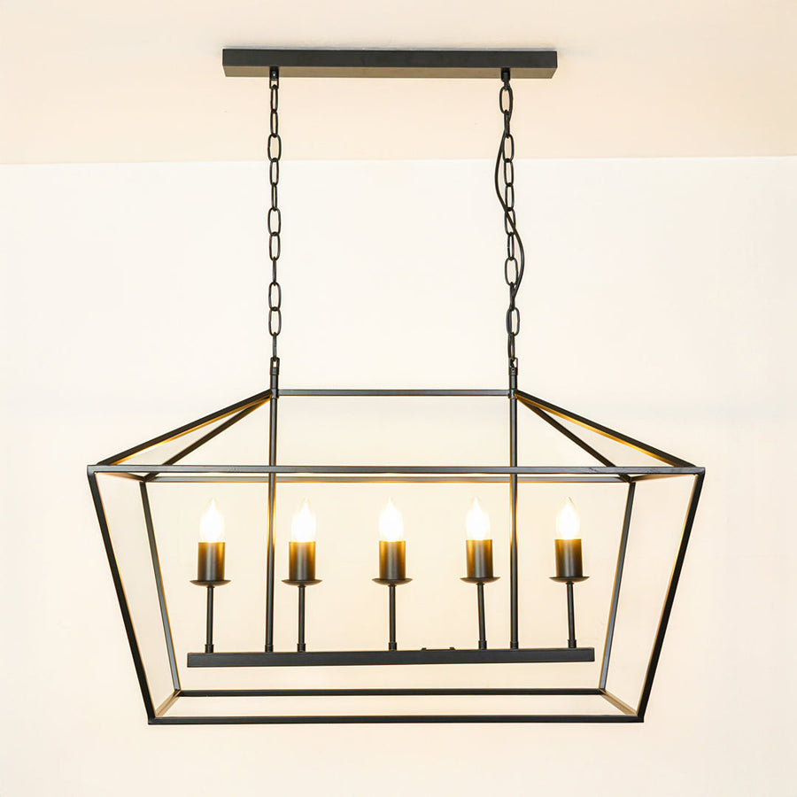 Contemporary black metal linear pendant light with exposed bulbs in geometric cage design hanging against neutral wall background for modern decor.