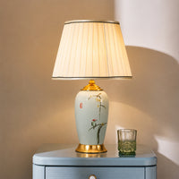 Decorative table lamp with pleated shade on a wooden surface, softly lit.