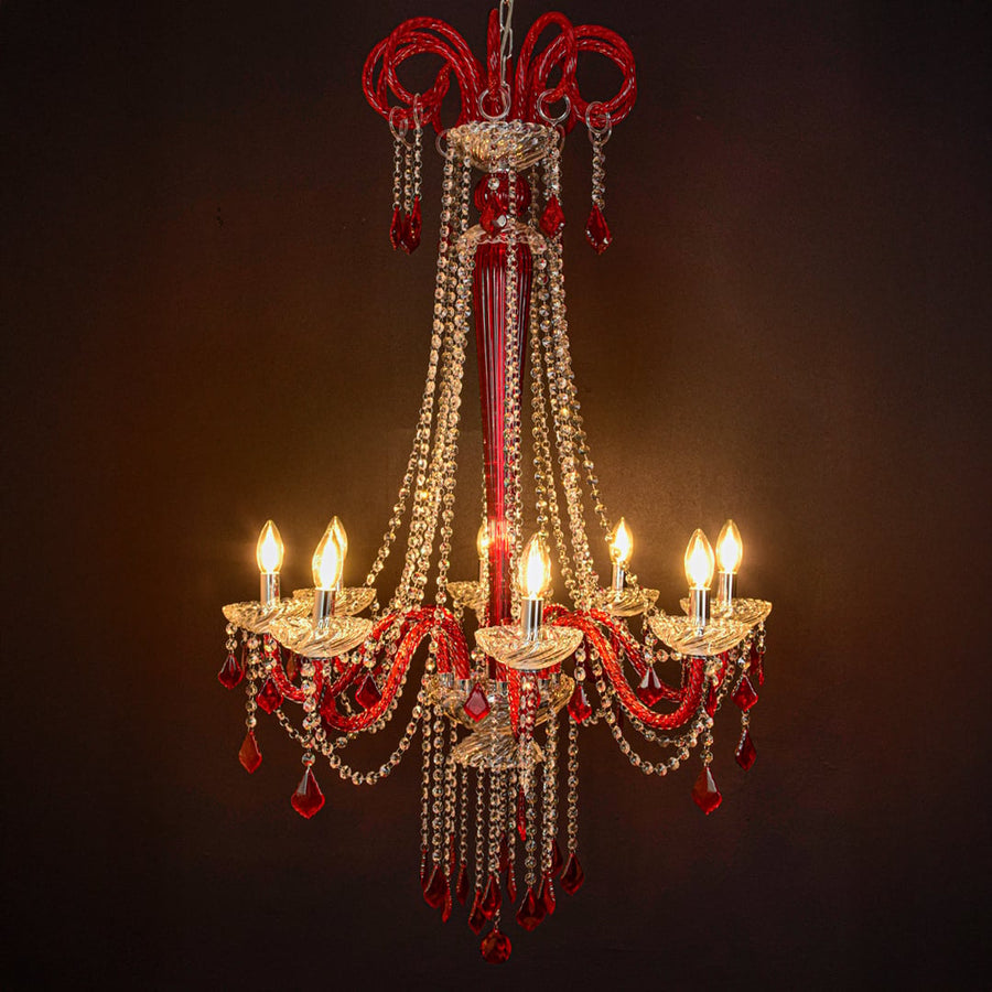 Red and clear crystal chandelier glowing softly on black background creating a dramatic luxury ceiling feature.