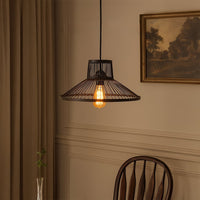 Black metal pendant light above dining area adding rustic industrial charm and cozy ambiance.