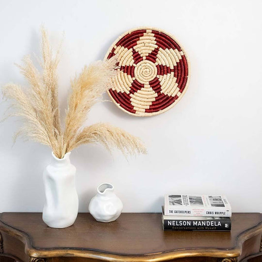 Lifestyle image of nora magic red handwoven sabai grass hanging wall basket for elegant modern living room decor styling.