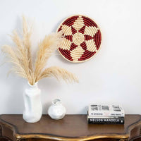 Lifestyle image of nora magic red handwoven sabai grass hanging wall basket for elegant modern living room decor styling.