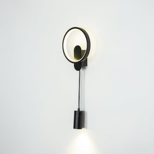 Contemporary gold wall sconce with LED ring and black spotlight mounted on neutral wall background ideal for modern bedroom or hallway lighting.

