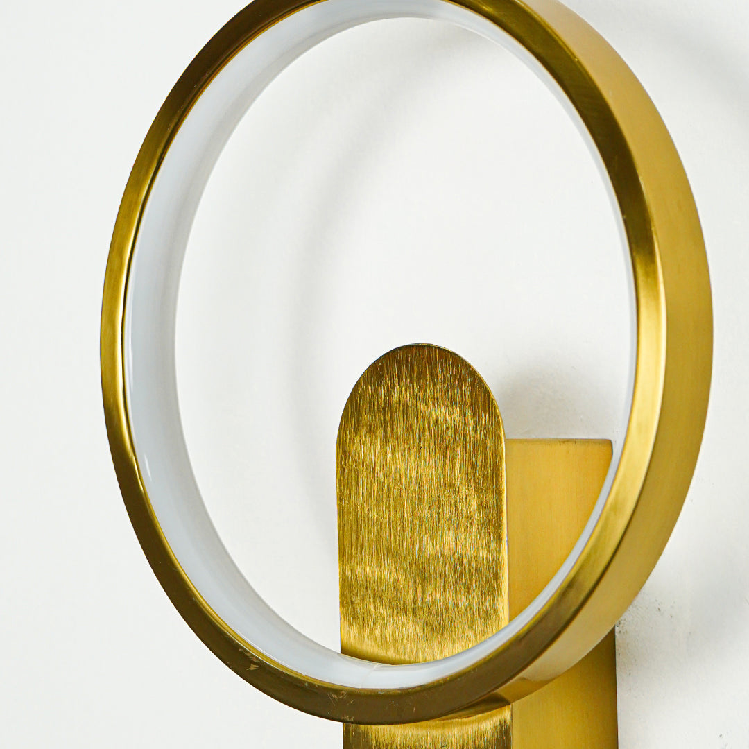 Close view of gold wall light with round frame and textured metal spotlight shade highlighting premium modern decorative lighting design.

