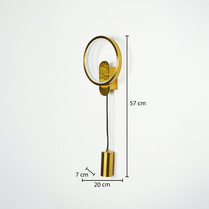Gold wall light with circular frame and hanging cylindrical pendant on neutral wall background 57 cm height 20 cm width 7 cm depth ideal for modern bedroom lighting.