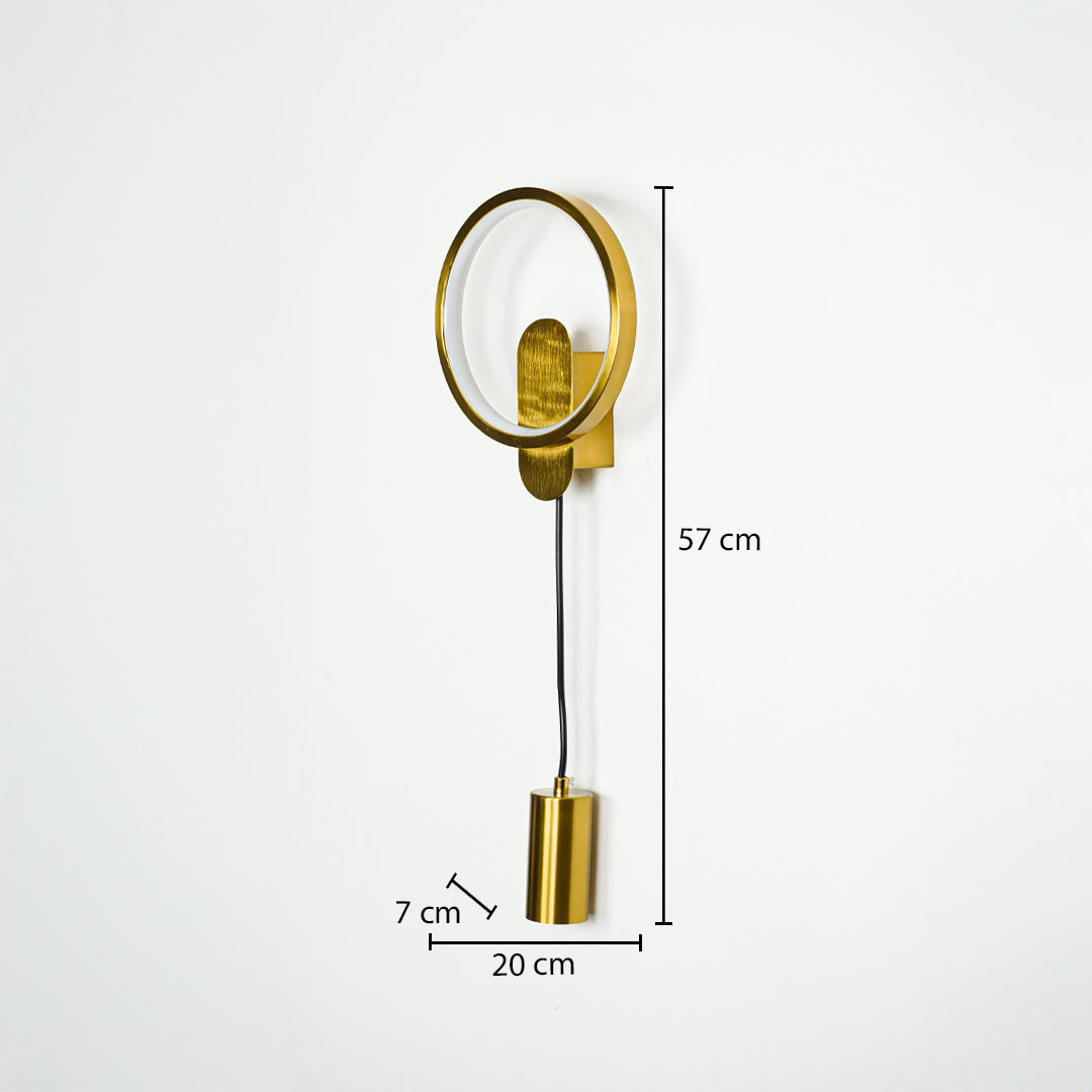 Gold wall light with circular frame and hanging cylindrical pendant on neutral wall background 57 cm height 20 cm width 7 cm depth ideal for modern bedroom lighting.