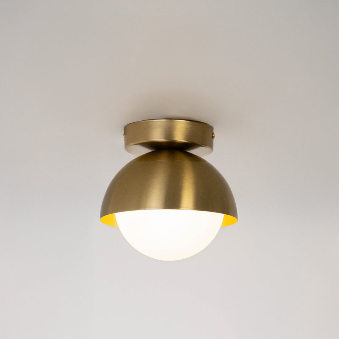 Modern gold metal ceiling light with white glass globe for luxury bedroom and premium interior decor spaces.