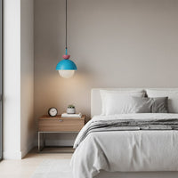 Blue and yellow pendant light beside the bed creating cozy ambiance with modern charm indoors.