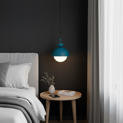 Blue pendant light above bedside table bringing soft illumination and contemporary sophistication.