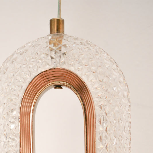 Detailed closeup of textured glass and rose gold metal oval led wall sconce pendant light fixture for modern home decor.