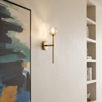 Modern brass wall light creating warm ambient lighting in stylish living room interior decor.