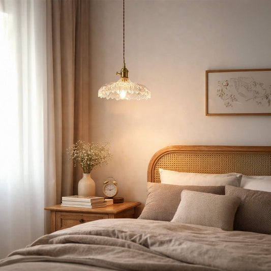 Clear embossed glass pendant light with gold accents illuminating bedroom decor with warm elegance.