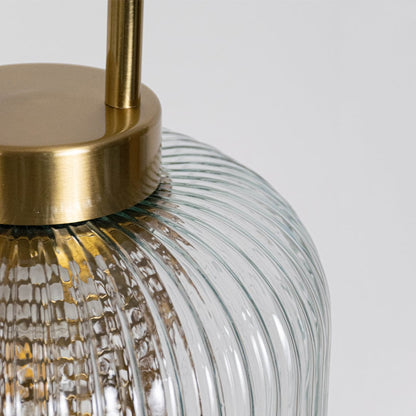 Closeup of clear ribbed glass and gold metal pendant light highlighting premium texture and finish.