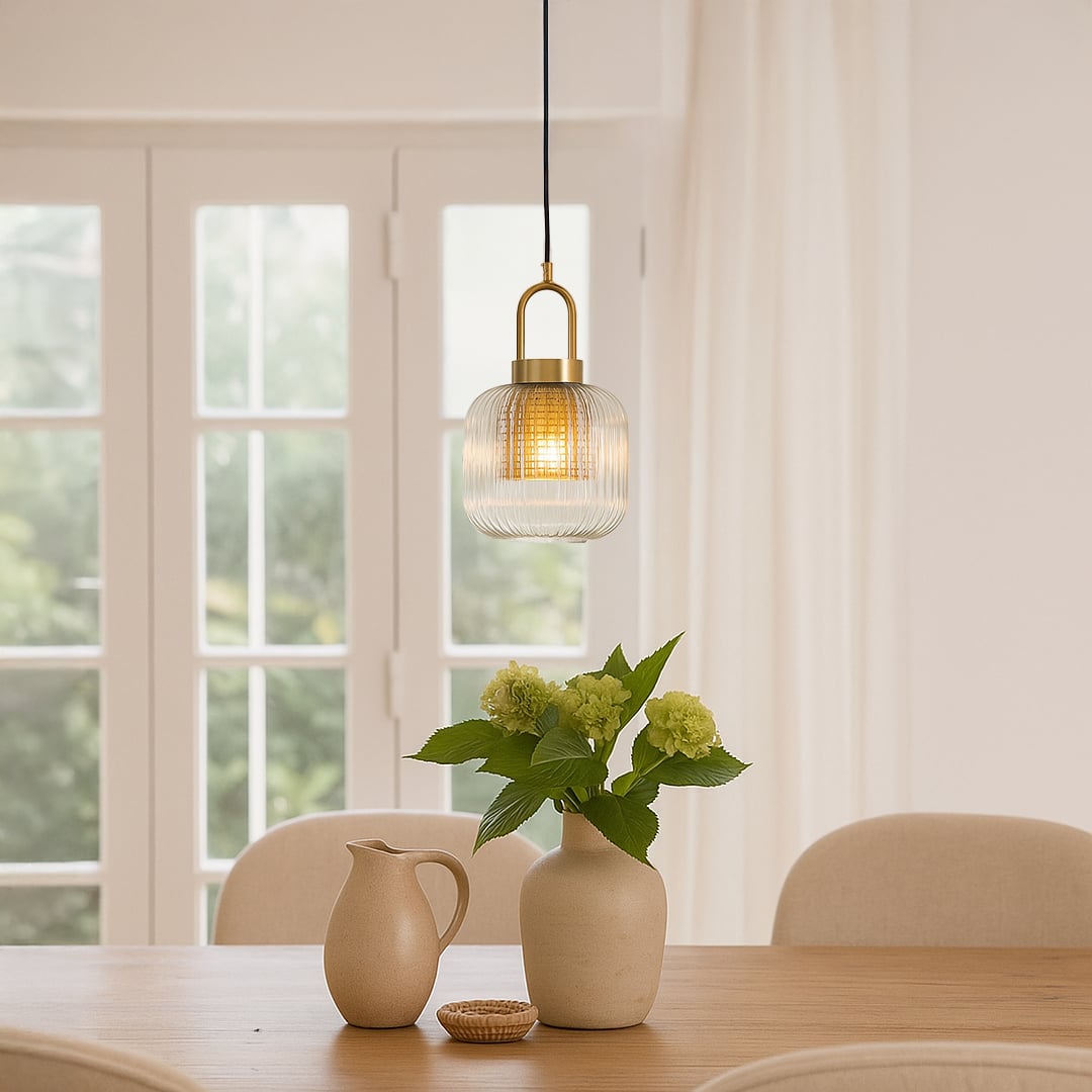 Clear ribbed glass and gold metal pendant light adding warm charm to bright dining room interiors.