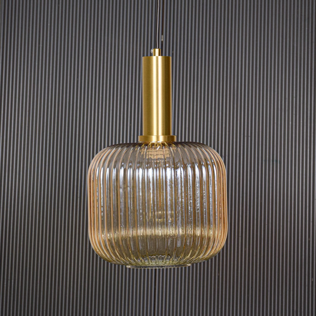 Gold metal and ribbed glass pendant light switched off displayed on black background showing clean shape and modern style.
