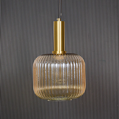 Gold metal and ribbed glass pendant light switched off displayed on black background showing clean shape and modern style.