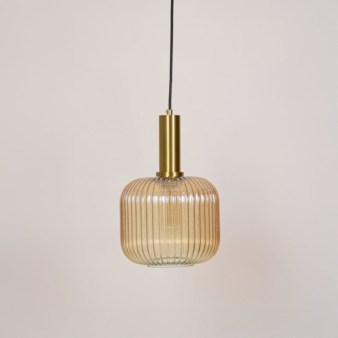 Modern gold metal and ribbed glass pendant light switched off on white background designed for ceiling mounted decor.