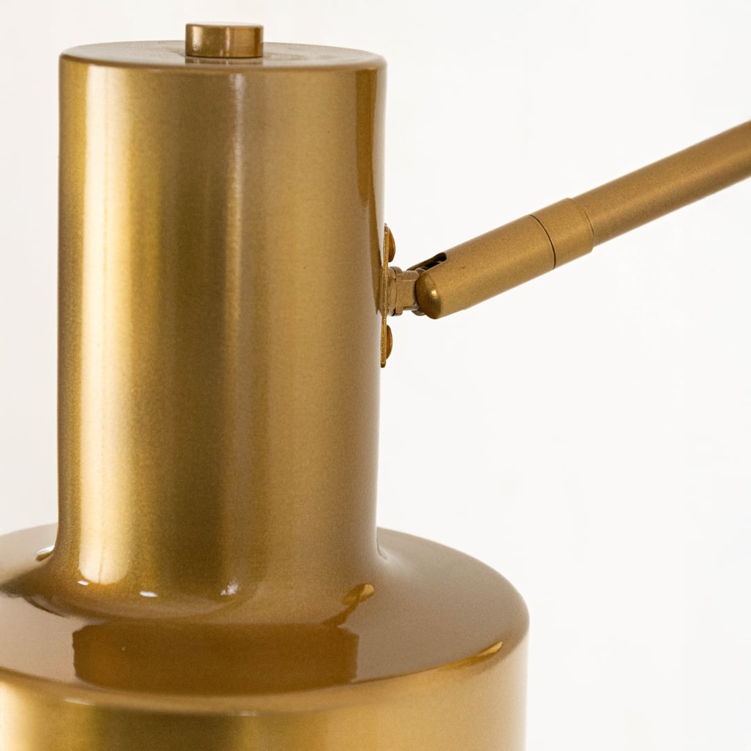A close detailed view of a gold wall light showing the cylindrical shade smooth brushed surface and sturdy mounting arm highlighting its refined modern build.