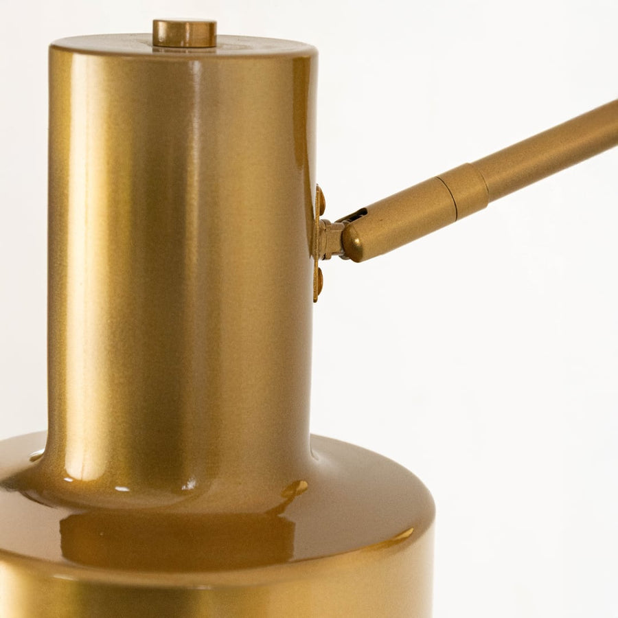 A close detailed view of a gold wall light showing the cylindrical shade smooth brushed surface and sturdy mounting arm highlighting its refined modern build.