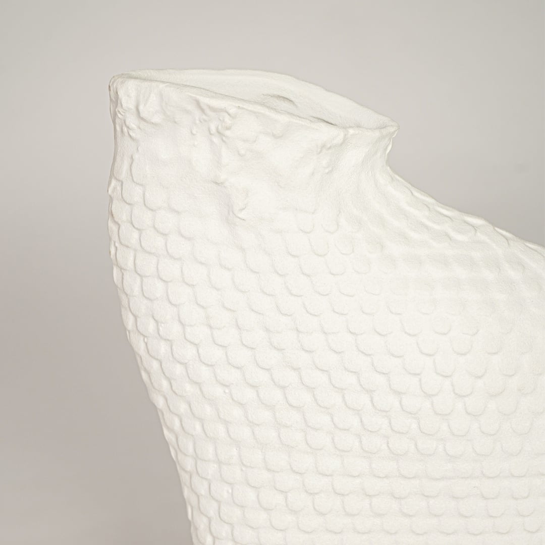 Closeup of white ceramic decorative vase with woven texture highlighting refined craftsmanship and modern styling.
