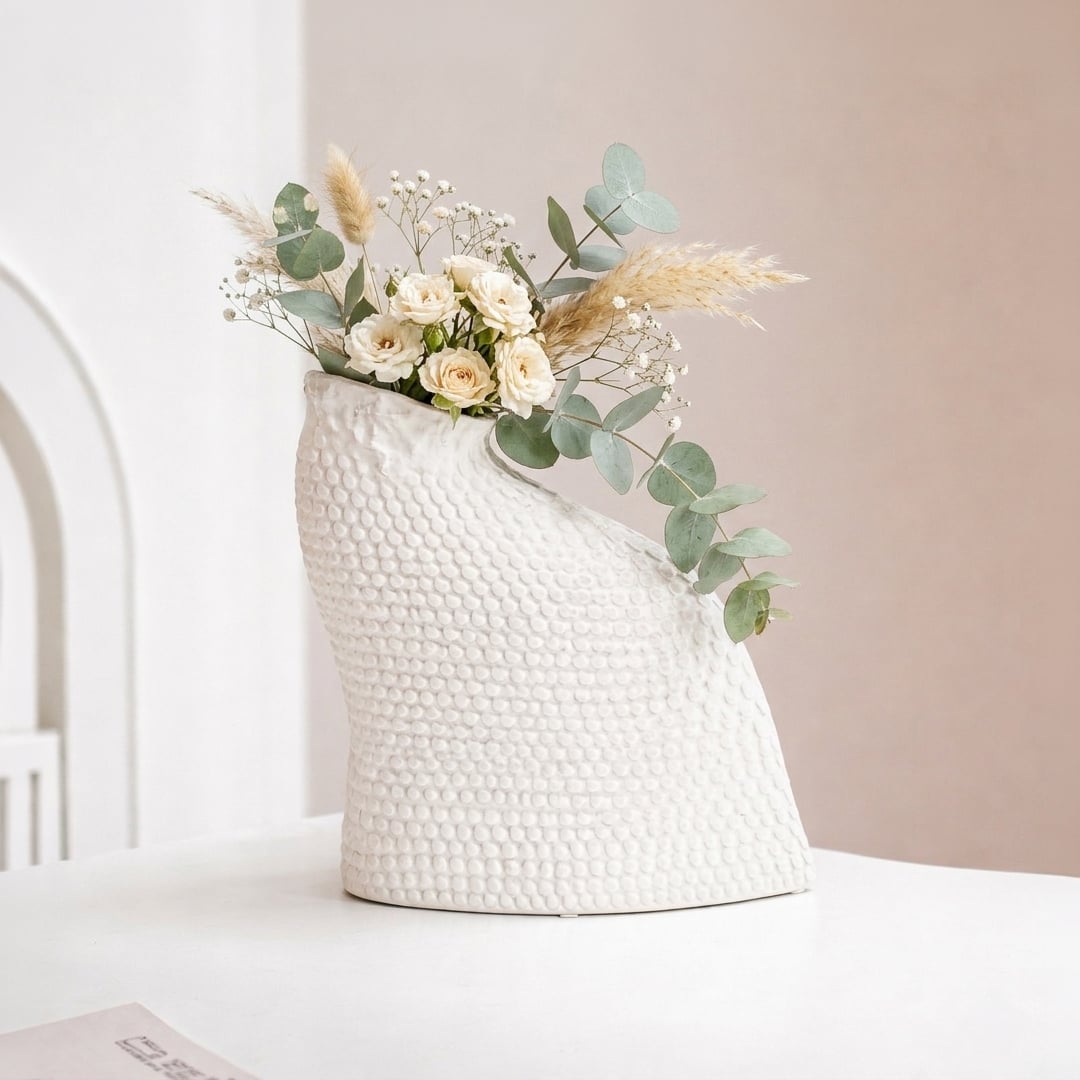 White ceramic decorative vase styled with flowers on a console table for elegant contemporary home decor settings.