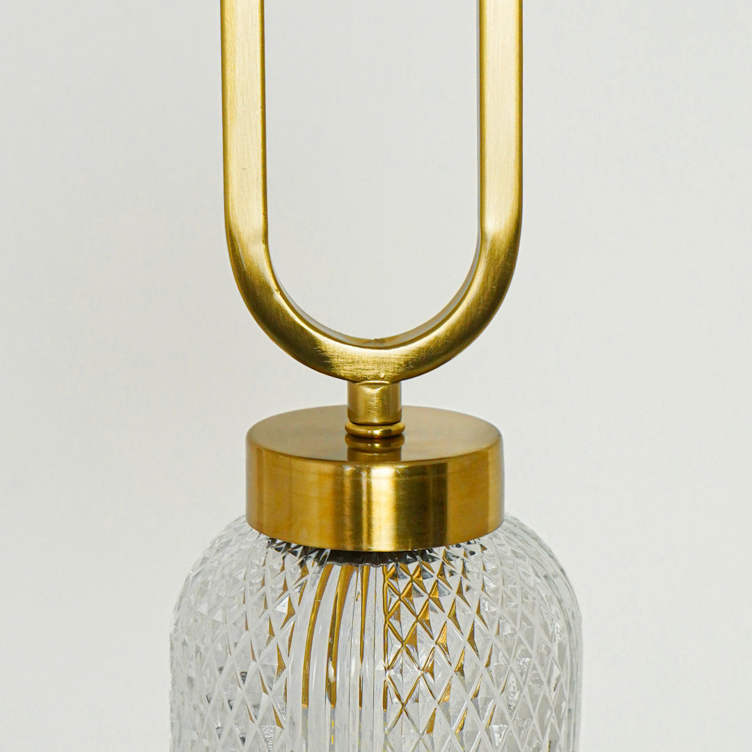 Closeup of textured clear glass and gold metal pendant light highlighting refined details and craftsmanship.